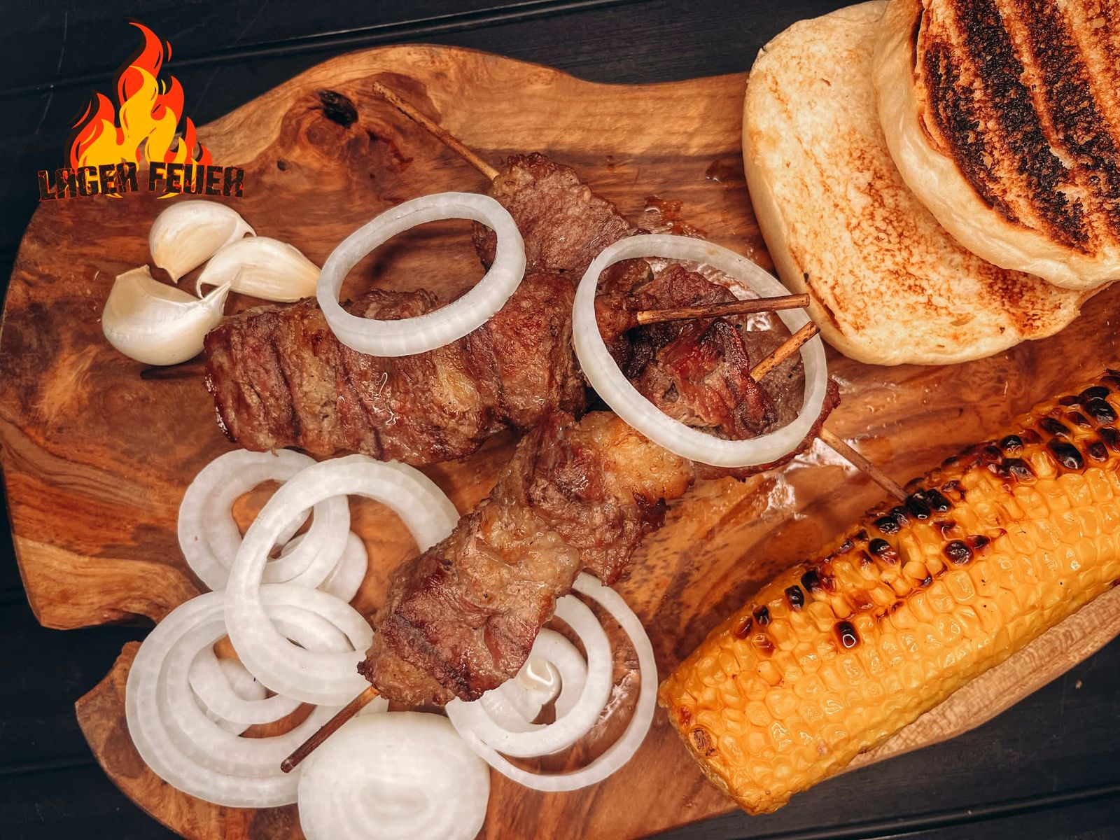 Gegrilltes Fleisch am Spieß mit Zwiebeln, Mais und Fladenbrot