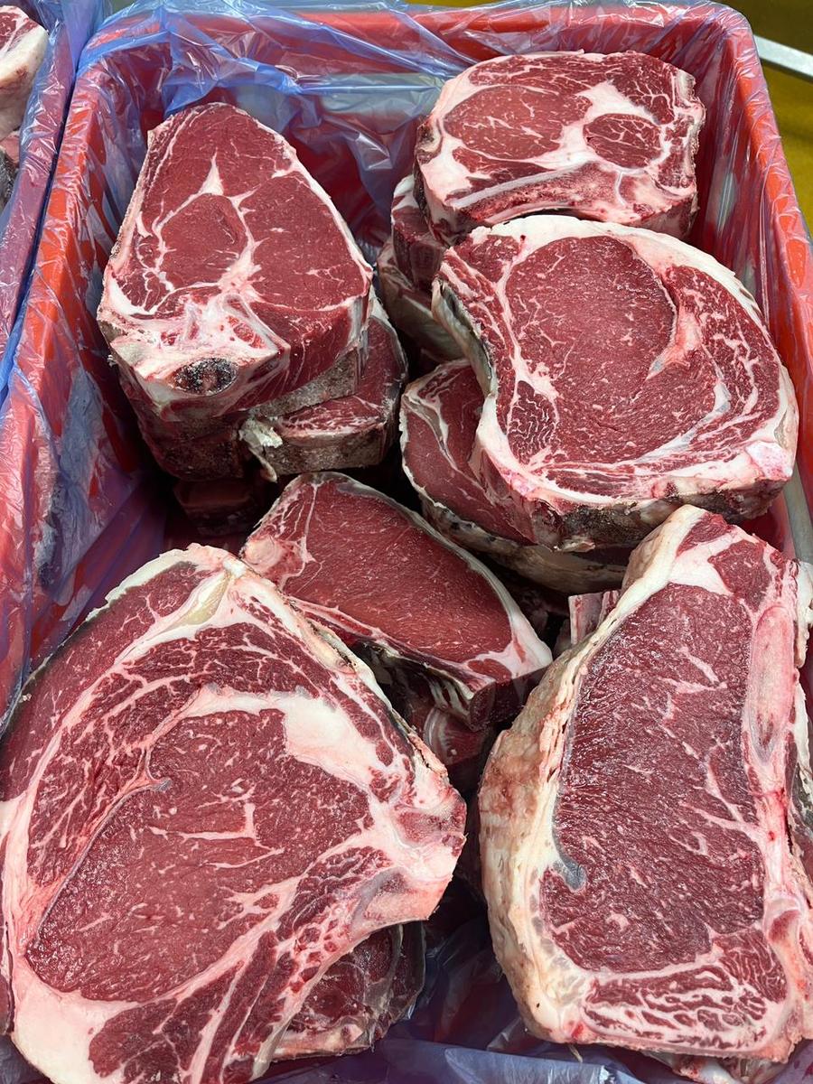 Ribeye und T-Bone dicht an dicht in der Kiste, Fettmarmorierung sichtbar