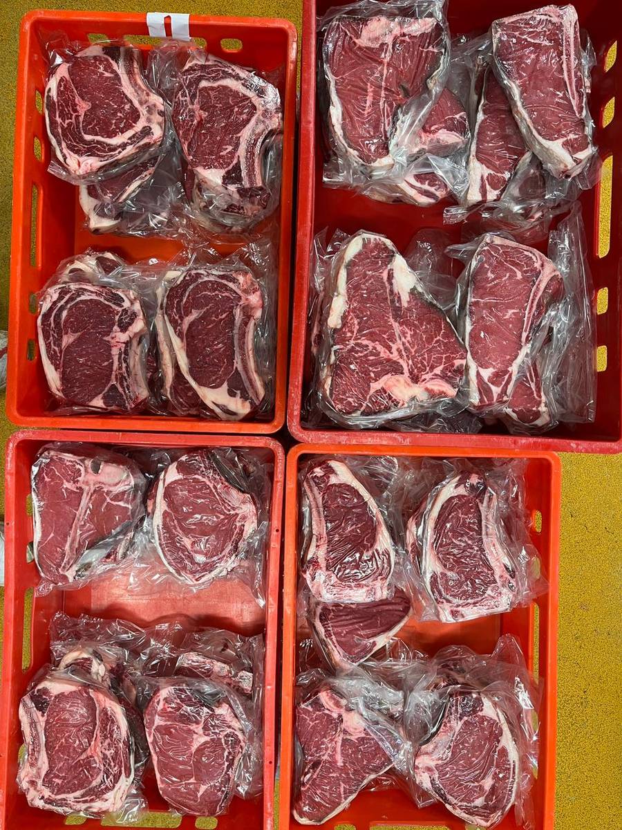 Vakuumierte Steaks in Folie, in roten Kisten sortiert