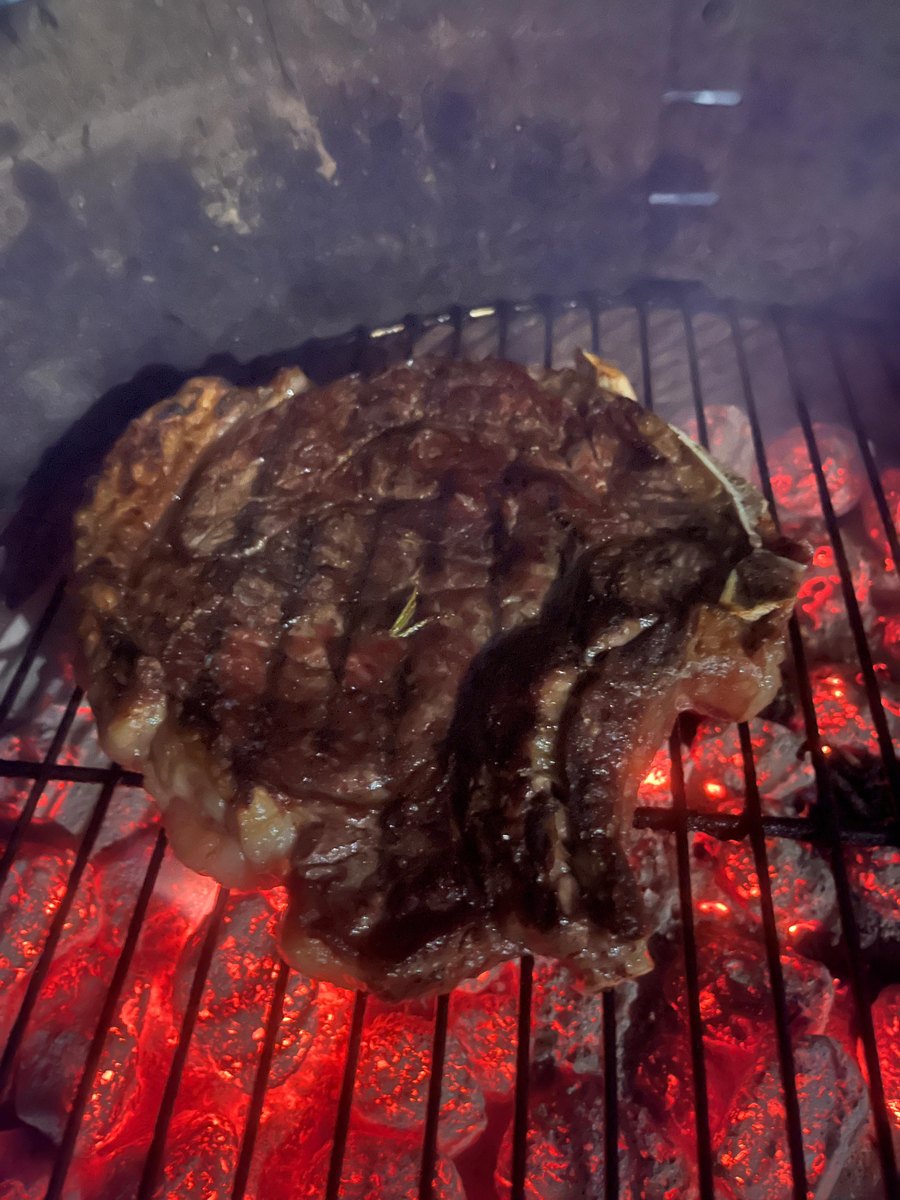Steak auf dem Grillrost über rot glühender Holzkohle